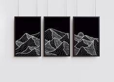 three black and white paintings hanging on the wall