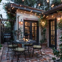 an outdoor dining area with patio furniture and string lights