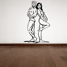 a man and woman standing next to each other in front of a wall with a drawing on it