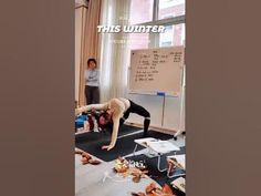 a person doing a handstand in front of a whiteboard