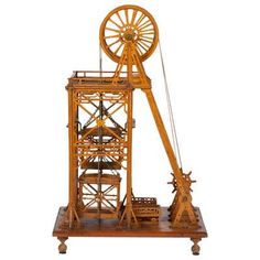 a wooden model of a ferris wheel on a stand with wheels attached to the top