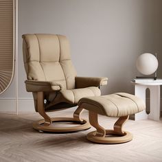 the reclining chair and ottoman are in front of a fan