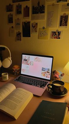 an open laptop computer sitting on top of a desk next to a cup of coffee