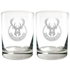 two shot glasses with the logo of milwaukee bucks on each one and an image of a deer's head