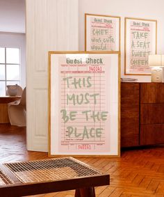 two framed posters on the wall in a room with wooden floors and hard wood flooring