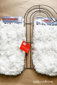 two oven mitts sitting on top of a wire rack next to a red tag