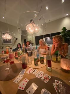 people sitting around a table with cards and wine glasses