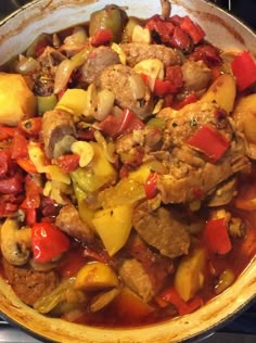 a pan filled with meat and vegetables on top of a stove