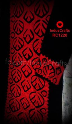 red and black fabric with an intricate design in the center, on a dark background