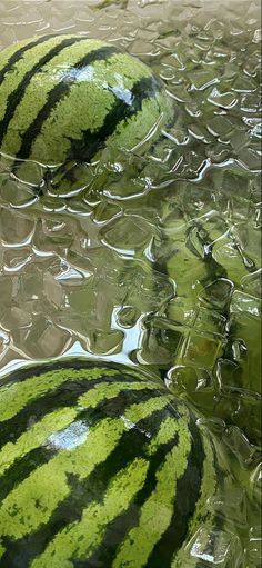 three watermelons sitting on top of each other in the middle of a puddle