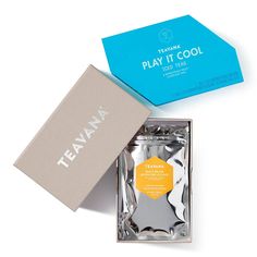 the teana play it cool gift box is open and sitting next to its packaging