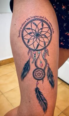 a woman's leg with a tattoo that has a dream catcher and quote on it