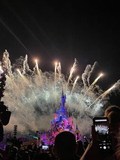 fireworks are lit up in the sky above a castle at disney's magic kingdom