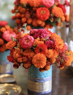 there are many flowers in the vases on the table and one is red, orange and yellow