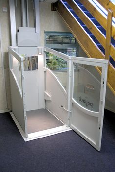 an open white refrigerator sitting inside of a kitchen next to a stair case and window