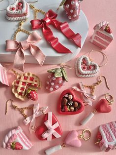 there are many different types of items on this pink tablecloth, including heart - shaped candies and other decorative objects