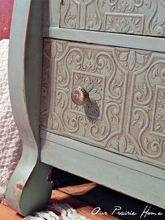 an old dresser with ornate carvings on the doors and drawer knobs is shown in this image