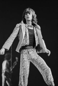 a woman standing on top of a stage with her legs spread out in the air