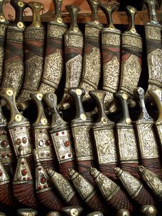 many different types of knives are lined up on a rack in front of each other