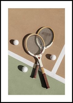 two tennis racquets and balls on a court