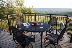 an outdoor table and chairs on a deck