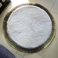 a round white rug sitting on top of a tiled floor