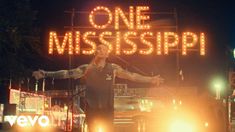 a man standing on top of a truck in front of a sign that says one mississippi