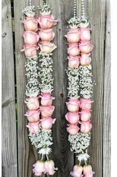 pink roses and baby's breath hanging from a wooden fence with flowers in the middle