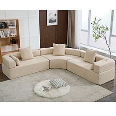 a living room with a large sectional couch and rug on the floor in front of a window