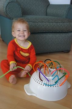 a little boy sitting on the floor with toothbrushes in front of him