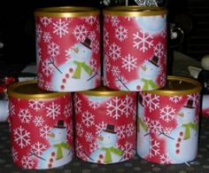 six tins with snowmen on them sitting next to each other in front of christmas decorations