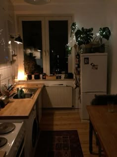 a kitchen with a stove top oven sitting next to a refrigerator freezer under a window