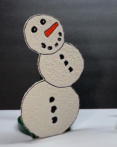 a snowman made out of paper sitting on top of a table