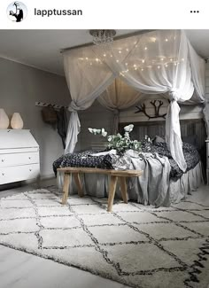 a bedroom with white curtains and lights on the ceiling is decorated in black and white