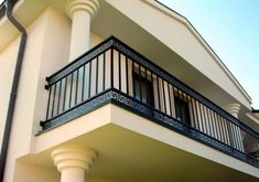 a white building with black balconies and balcony railings