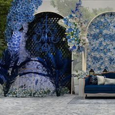 a blue couch sitting next to a wall covered in flowers