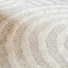 a dog laying on top of a bed covered in white fluffy blankets and paw prints