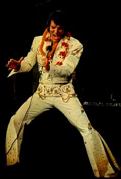 elvis presley performing on stage with microphone in hand