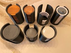 there are many different types of cups on the counter top, including one with a wooden lid