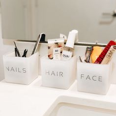 three containers with hair products in them sitting on a bathroom sink counter next to a mirror