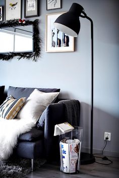 a living room filled with furniture and pictures hanging on the wall next to a lamp