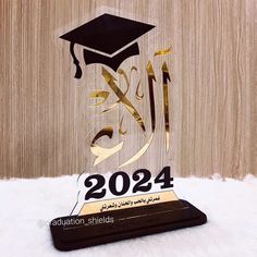 the graduation trophy is on display in front of a wooden wall and white furnishing