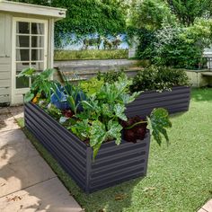 two large planters filled with lots of plants on top of a lush green field