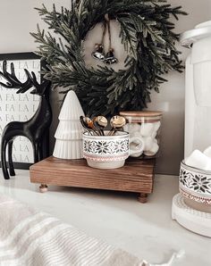 a christmas wreath is hanging on the wall above a bowl and other items in front of it