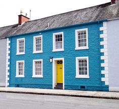 a blue and white building with a yellow door