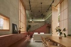 the interior of a modern building with wooden tables and benches in front of large windows