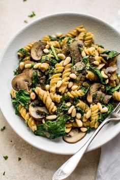 a white bowl filled with pasta and mushrooms