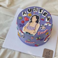 there is a purple cake with an image of a woman on the top and words above it