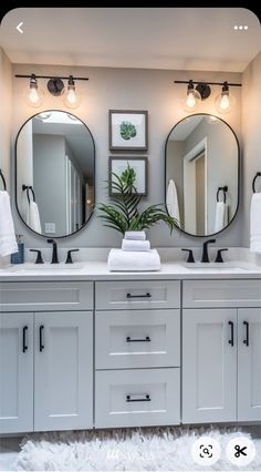 a bathroom with two sinks and three mirrors