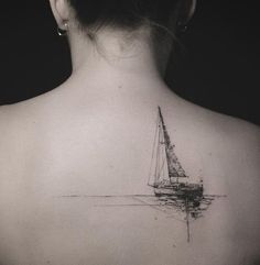 the back of a woman's neck with a sailboat tattoo on it,